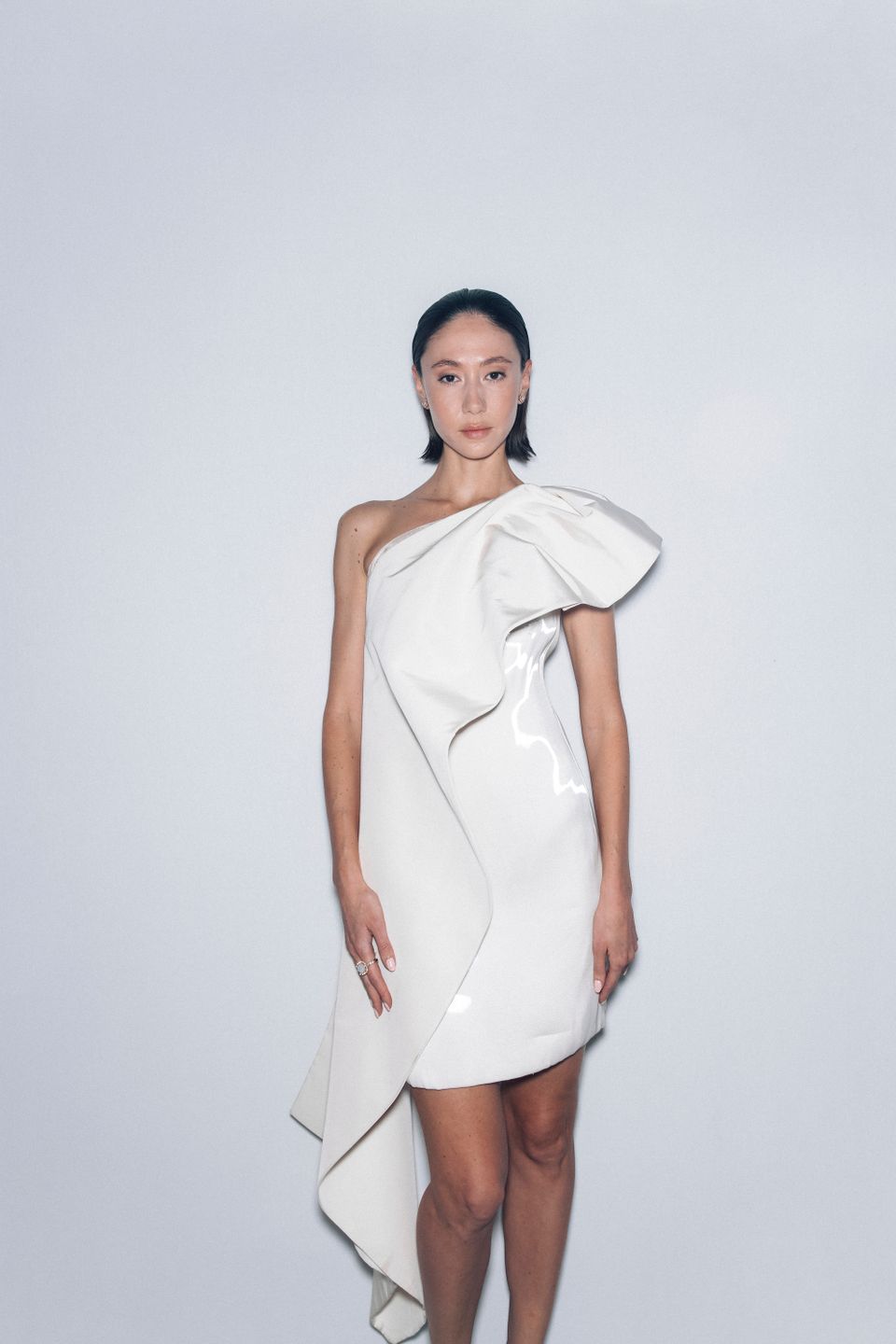 Model in a white asymmetric dress on the runway